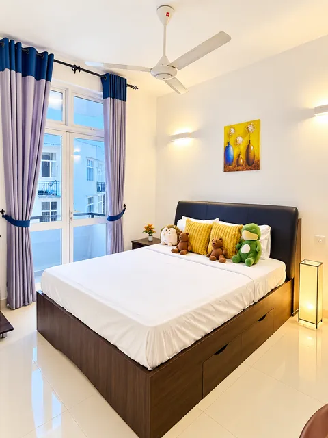Bright bedroom with double bed and blue curtains