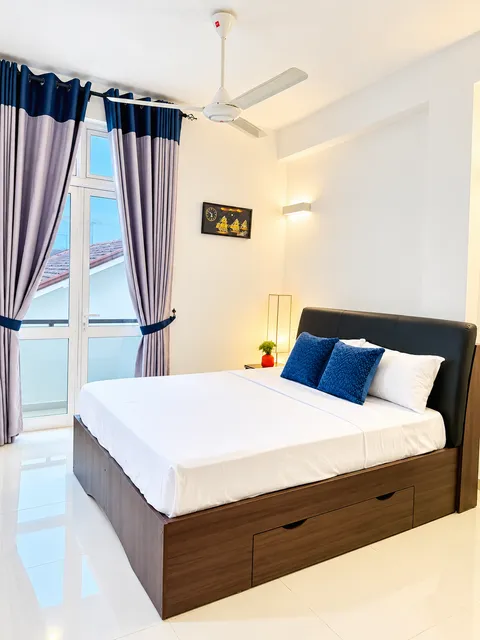 Guest bedroom with ceiling fan and balcony doors